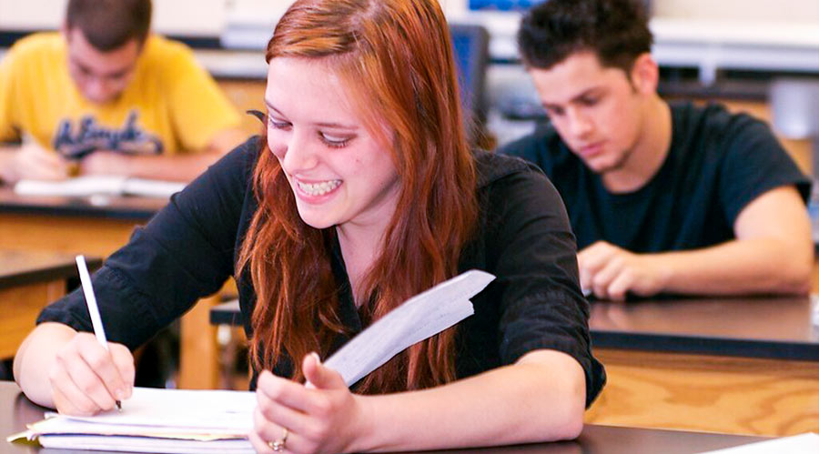 young woman with red hair sitting in class