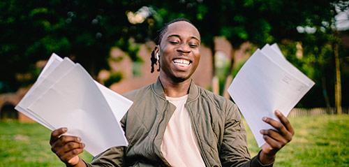 Young African American man holding papers and smiling